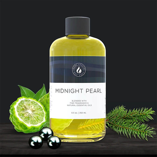 Midnight Pearl diffuser oil in an 8.5 oz bottle, surrounded by bergamot, fir needles, and black pearls to evoke a deep, woody, and refined fragrance blend.